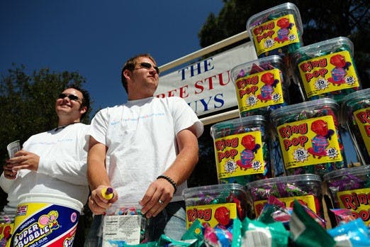 The Free Stuff Guys - Trevor Jordan, left, and David Knuckles - hand out Ring Pops in Smith Plaza on Thursday. 