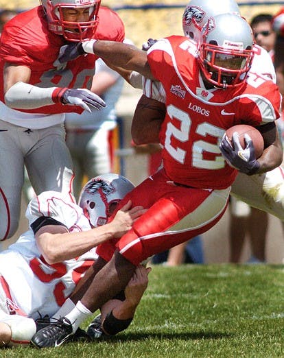 UNM tailback Rodney Ferguson tries to escape a tackle during Saturday's Cherry versus Silver game at Ivan Head Stadium in Santa Fe. Cherry defeated Silver 35-7. 
