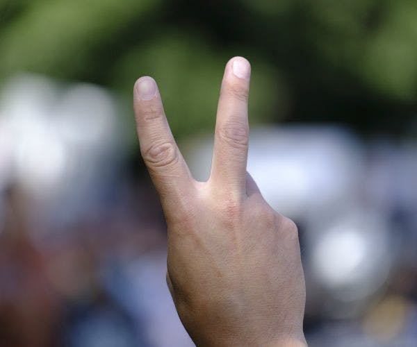 A peace sign is thrown up in the air.