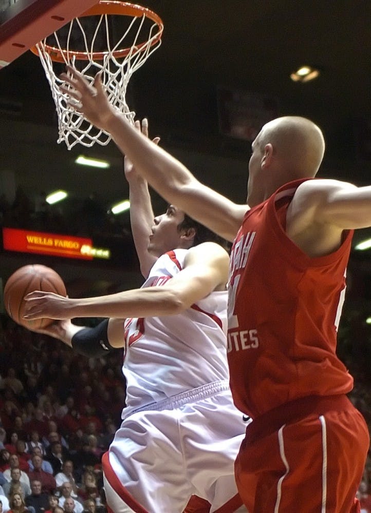 Utah's Shaun Green tries to block a layup by Lobo forward Daniel Faris during Tuesday's game at The Pit. The Lobos won 77-67.