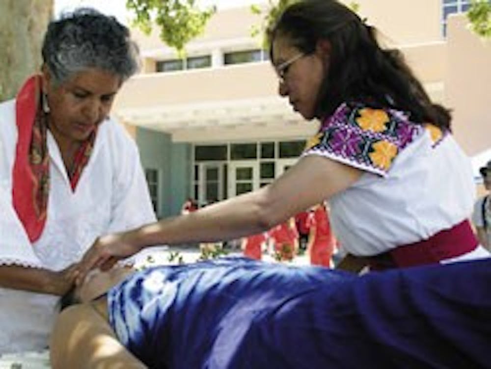 Michele Rozbitsky of Santa Fe receives a massage from Virginia Tapia, left, and Micaela Perez during Friday's 2nd Annual Mexican Traditional Medicine Fair north of the SUB.