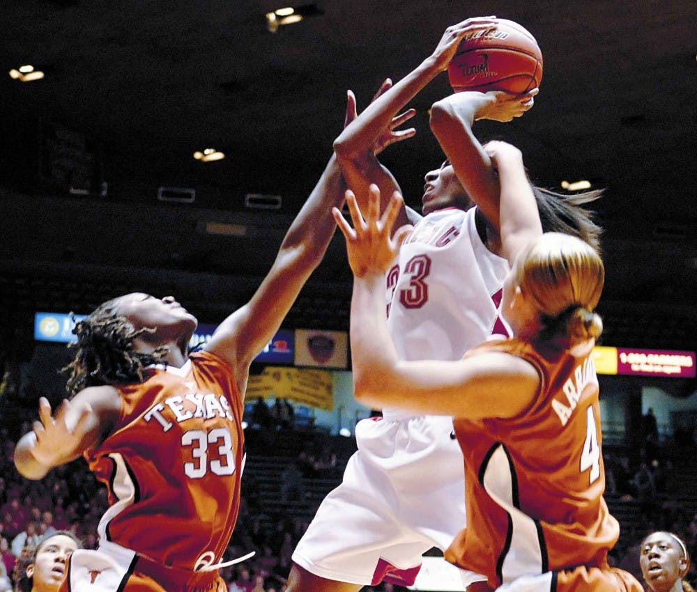 Lobo forward Dionne Marsh is fouled by Texas' Tiffany Jackson, left, and Erika Arriaran in the second half of the Lobos' 63-60 win at The Pit on Friday.