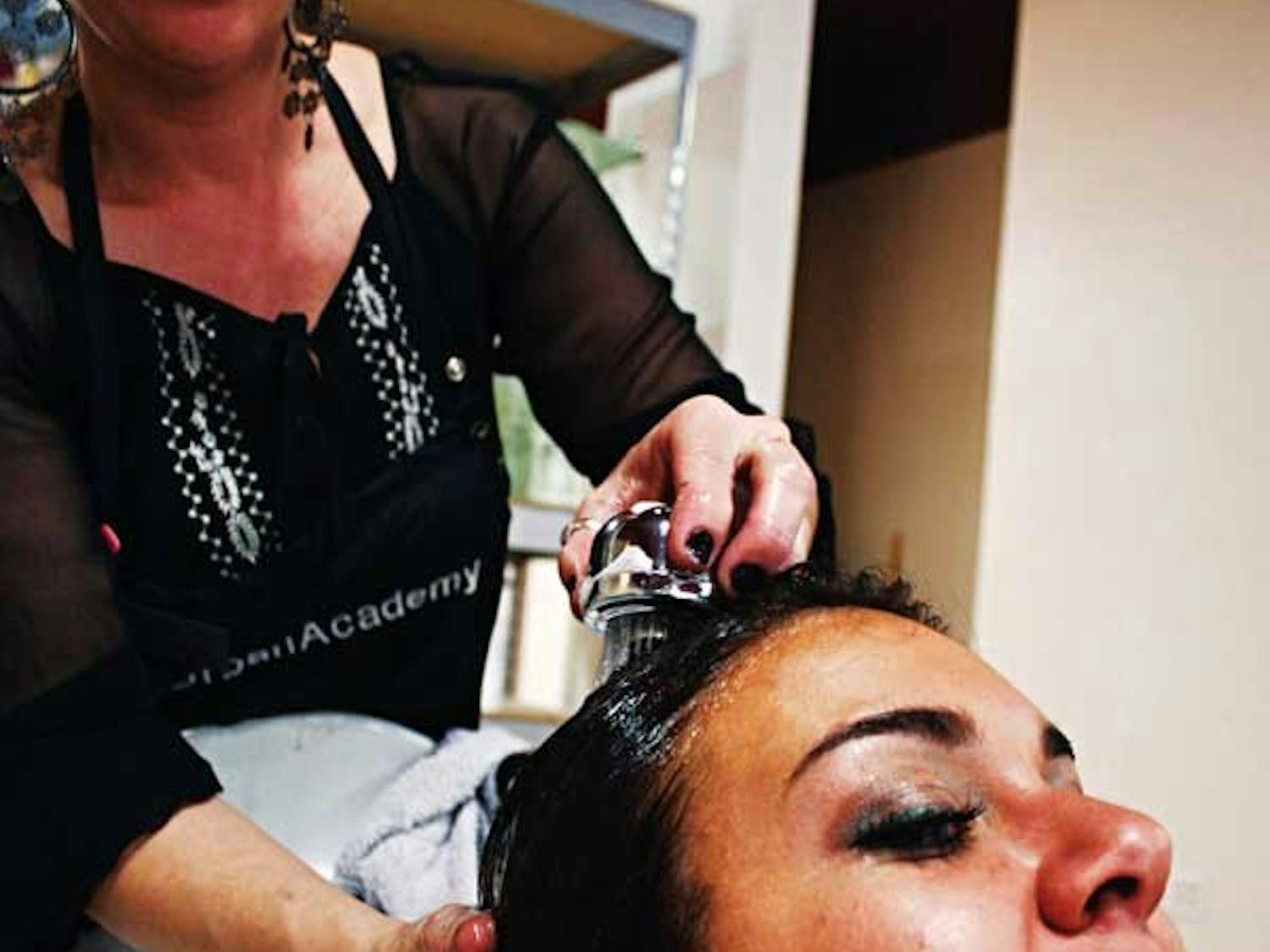 Stylist Paige Davis washes Amanda Schofield's hair Wednesday at Urban Academy. On Monday, customers can get a free shampoo, cut and style if they bring in five nonperishable foods.