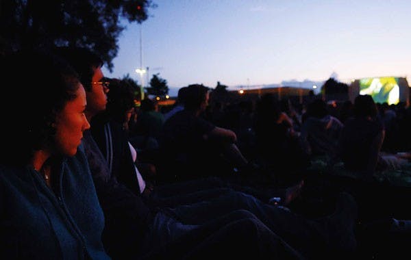 Freshmen Ashlei Mayo, left, and Joshua Gallegos watch Spider Man 3 on lower Johnson Field on Sunday. Student Special Events hosted the flick and gave out free popcorn. 