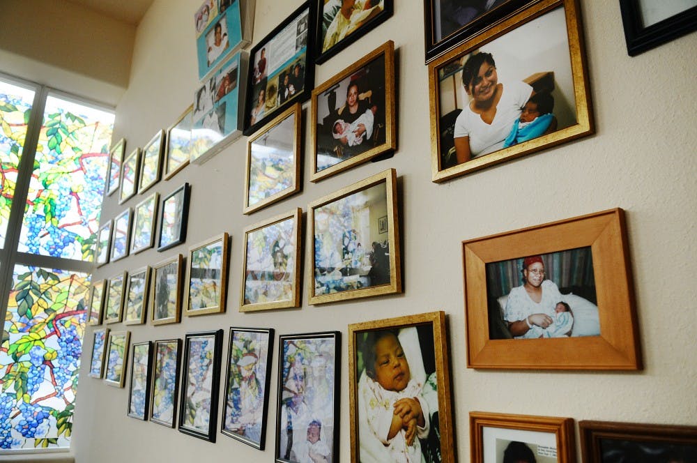 	A wall of photos in the Holy Innocents Center for Life depicts women and their newborn babies. 