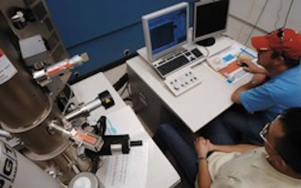 Graduate student Ping-Show Wong and research engineer Geoff Courtin look at an image from a scanning electron microscope Tuesday in the Farris Engineering Center. 