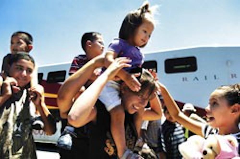 Angelina Abeyta, right, helps her 2-year-old cousin, Kathleen Abeyta, onto Alexis Abeyta's shoulders after the family rode the Rail Runner Express from Bernalillo to Alvarado Station in Downtown on Wednesday.