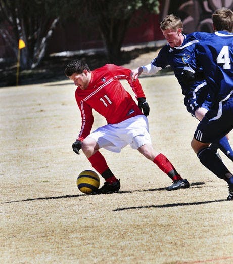 P.J. Wilson shields the ball from Fort Lewis defenders on Saturday at Robertson Field. Wilson put the Lobos up 1-0 early, and UNM held off the Skyhawks 2-1.