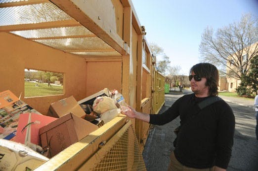Student Adam Barber throws his water bottle in a recycling bin on Tuesday. The Safety & Risk Services department removed fourteen recycling bins from the Student Family Housing complex and South Campus two weeks ago.