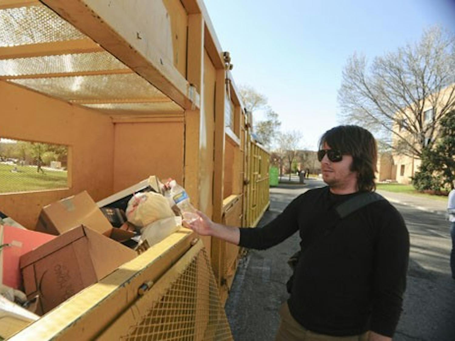 Student Adam Barber throws his water bottle in a recycling bin on Tuesday. The Safety & Risk Services department removed fourteen recycling bins from the Student Family Housing complex and South Campus two weeks ago.