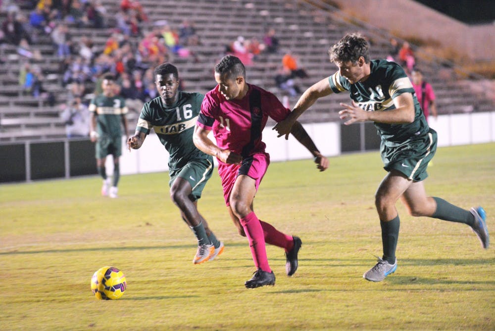 Junior forward Niko Hansen&nbsp;fights past two UAB players at the UNM Soccer Complex Sunday, Oct. 18, 2015. The Lobos play the 49ers Tuesday at 7 p.m..