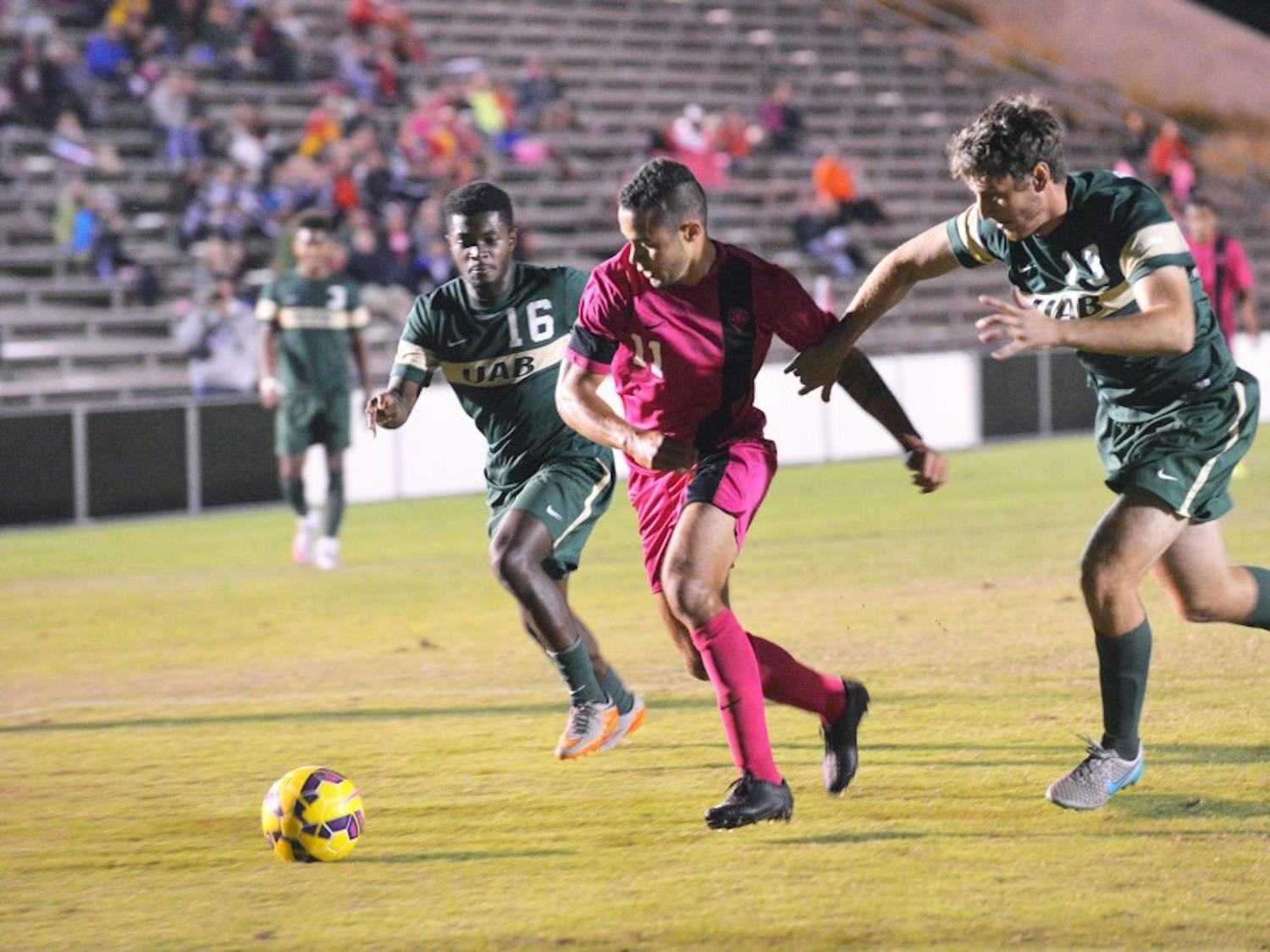 Junior forward Niko Hansen&nbsp;fights past two UAB players at the UNM Soccer Complex Sunday, Oct. 18, 2015. The Lobos play the 49ers Tuesday at 7 p.m..