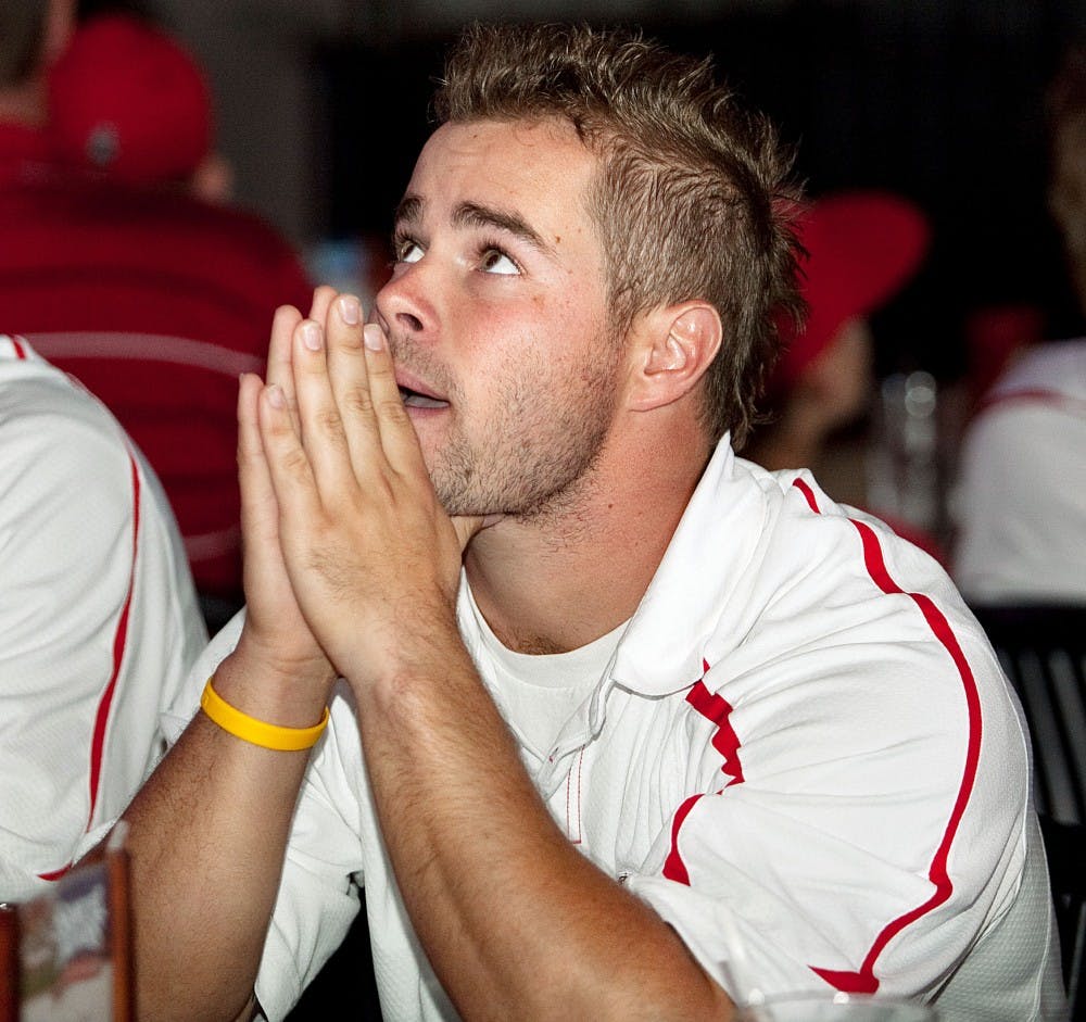 	UNM senior Adam Courcha watches one of the many TVs at Coaches Sports Grill, while awaiting the announcement of the Lobos’ NCAA at-large tournament berth Monday. The Lobos will play Stanford in the opening round of the tournament this week.