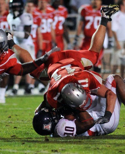 Lobo Clint McPeek tackles Arizona's Mike Thomas during Saturday's game at University Stadium. The Lobos won 36-28.  