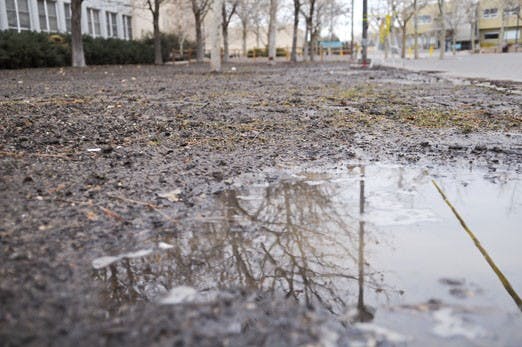Water collects in puddles in the muddy yard outside Castetter Hall on Sunday after the sprinkler system flooded the area. The runoff filled half a block of Redondo Drive in front of Marron Hall. 