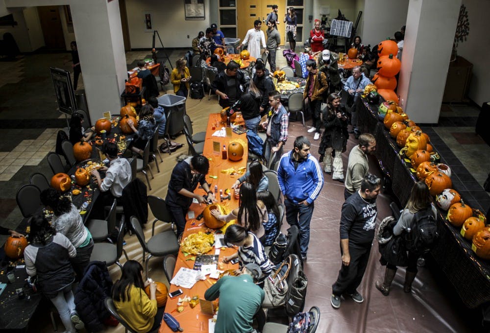 People gather to watch and carve pumpkins at the SUB during the Pumpkin Carving Contest on Oct. 31, 2017.