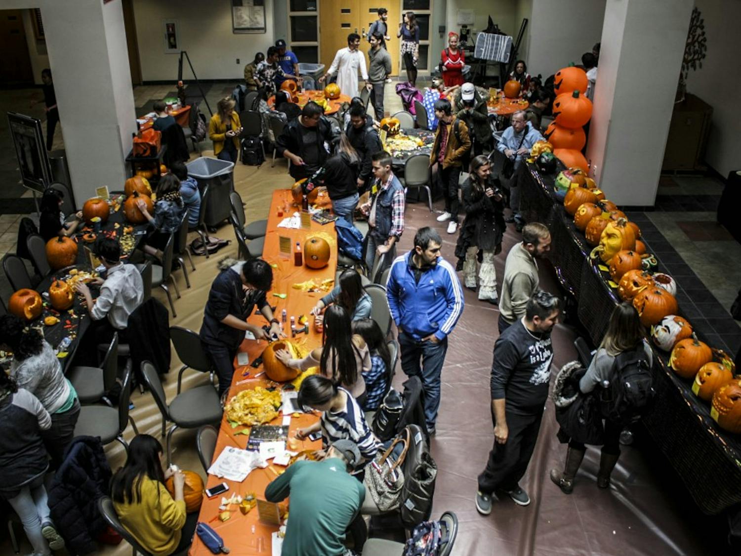People gather to watch and carve pumpkins at the SUB during the Pumpkin Carving Contest on Oct. 31, 2017.