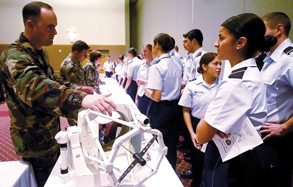 UNM alumnus Capt. Luke Davis, left, demonstrates a replica of the 3.5-meter telescope to cadet Britana Campos in the SUB on Wednesday at a career fair and conference sponsored by the Air Force ROTC.