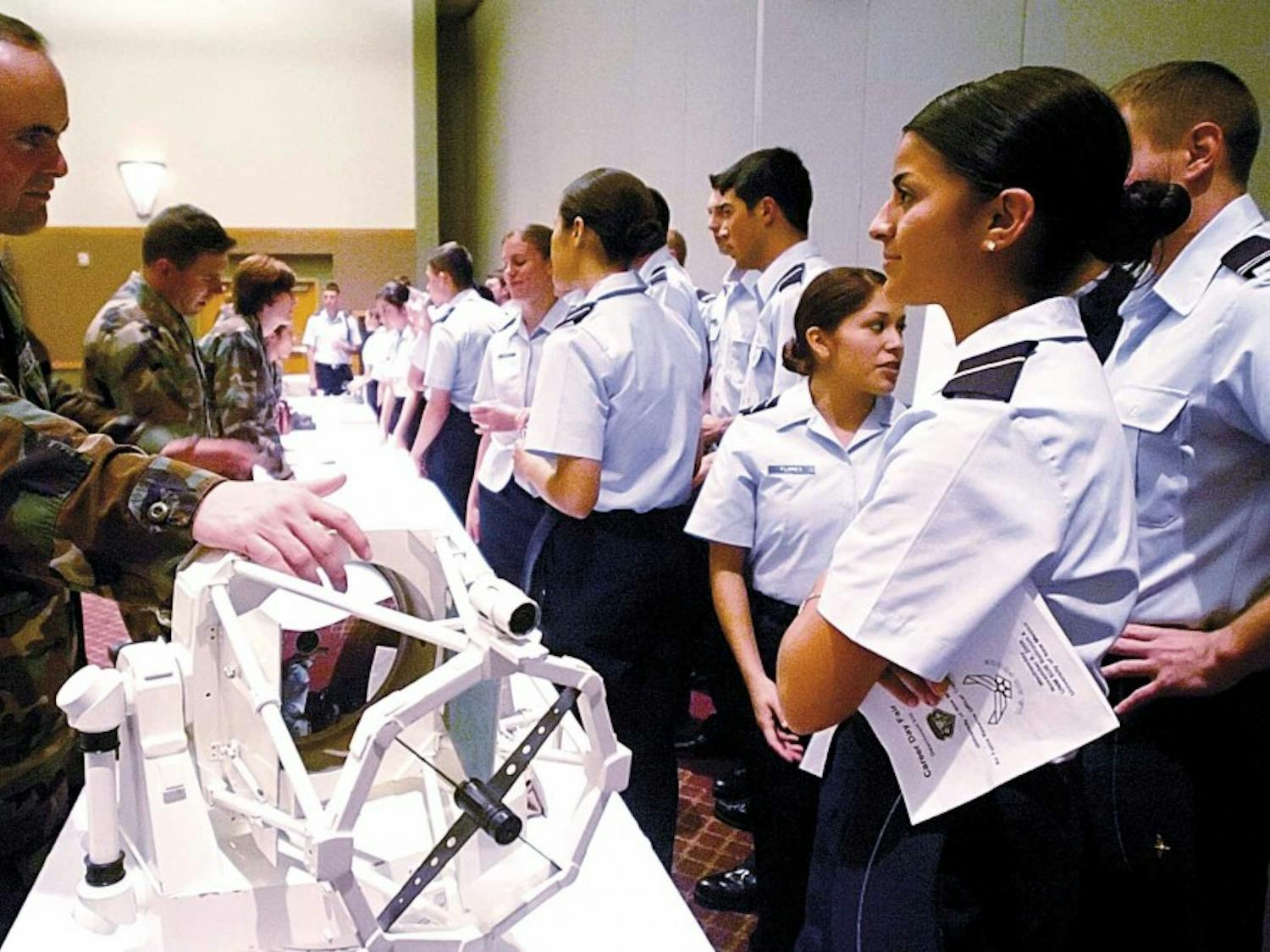 UNM alumnus Capt. Luke Davis, left, demonstrates a replica of the 3.5-meter telescope to cadet Britana Campos in the SUB on Wednesday at a career fair and conference sponsored by the Air Force ROTC.