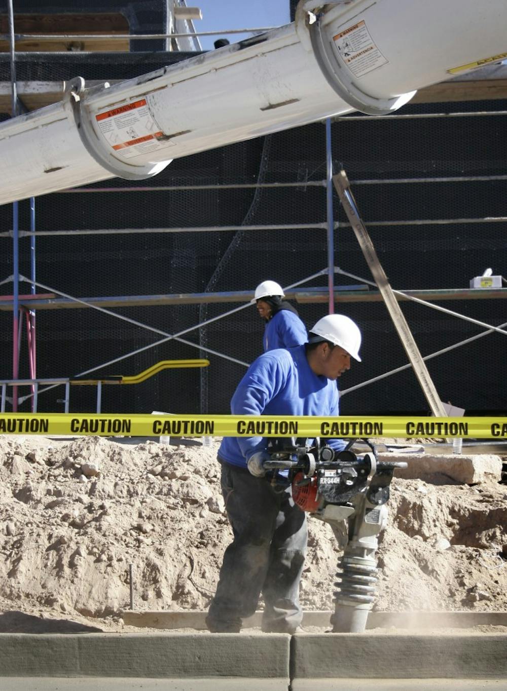 A construction worker compacts the ground as concrete is poured at the future home of the Martinez family. Being built by hundreds of workers and volunteers, the home will be featured on the show "Extreme Makeover: Home Edition."