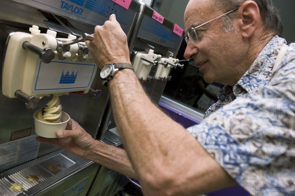 	Co-owner of Ellie’s Yoberri Park frozen yogurt, Marty Slonim, makes a pumpkin chocolate swirl yogurt cup Monday. The store had its grand opening on Halloween, though it’s been open since mid-October. 