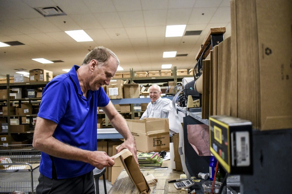 Larry Plumlee packs books before they are exported across the country.