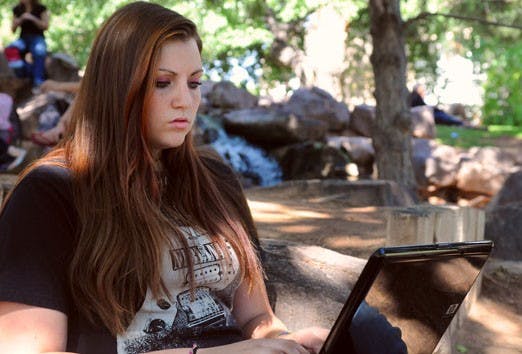 Student Samantha Davis works on her laptop on Monday at the Duck Pond. 