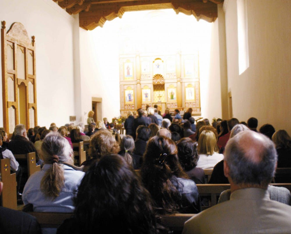 Friends and co-workers line up to give their condolences to the family of Greg Johnston, a senior communication representative in UNM's Communication and Marketing Department, during a memorial Thursday in the UNM Alumni Chapel. He died of cancer Feb. 14.