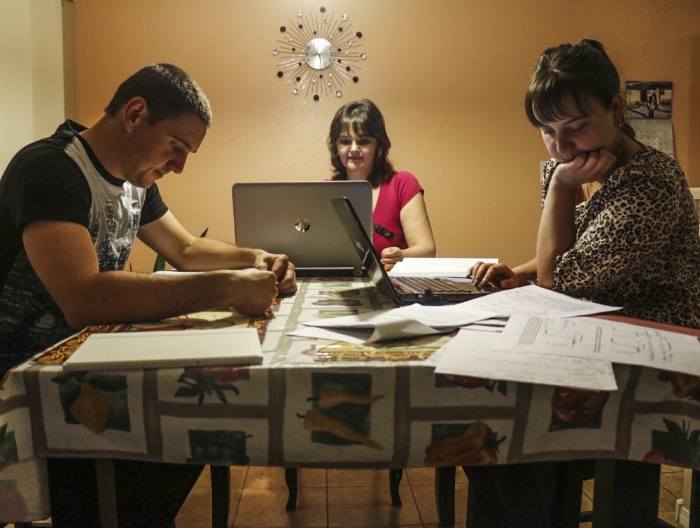Lyudmyla Kostyk, center, studies at UNM with her two children, who are also attending classes, on Saturday, Dec. 10, 2016.