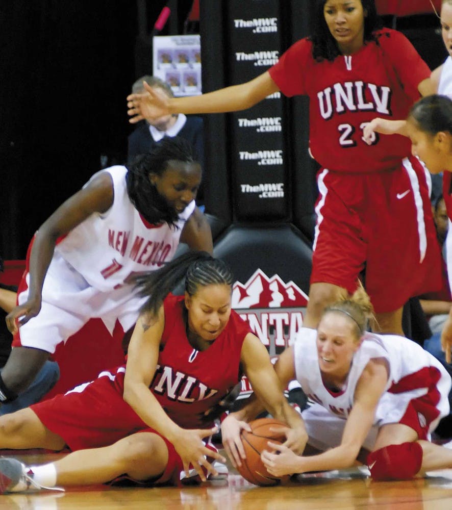 Guard Julie Briody fights with UNLV's Kim Koeven for possession of the ball during the first half of the quarterfinal game of the Mountain West Conference Tournament on Wednesday in Las Vegas. UNM won 80-52 and will face Wyoming today.