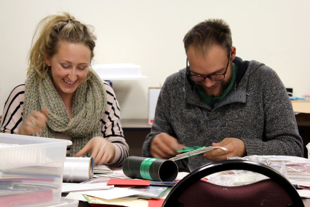 Johannah Maybach, left, and her boyfriend Andrew Stuntz volunteer at their first gift-wrapping event of the season at the UNM Continuing Education building. Maybach is a student from Ft. Lewis, while Stuntz studies at UNM.
