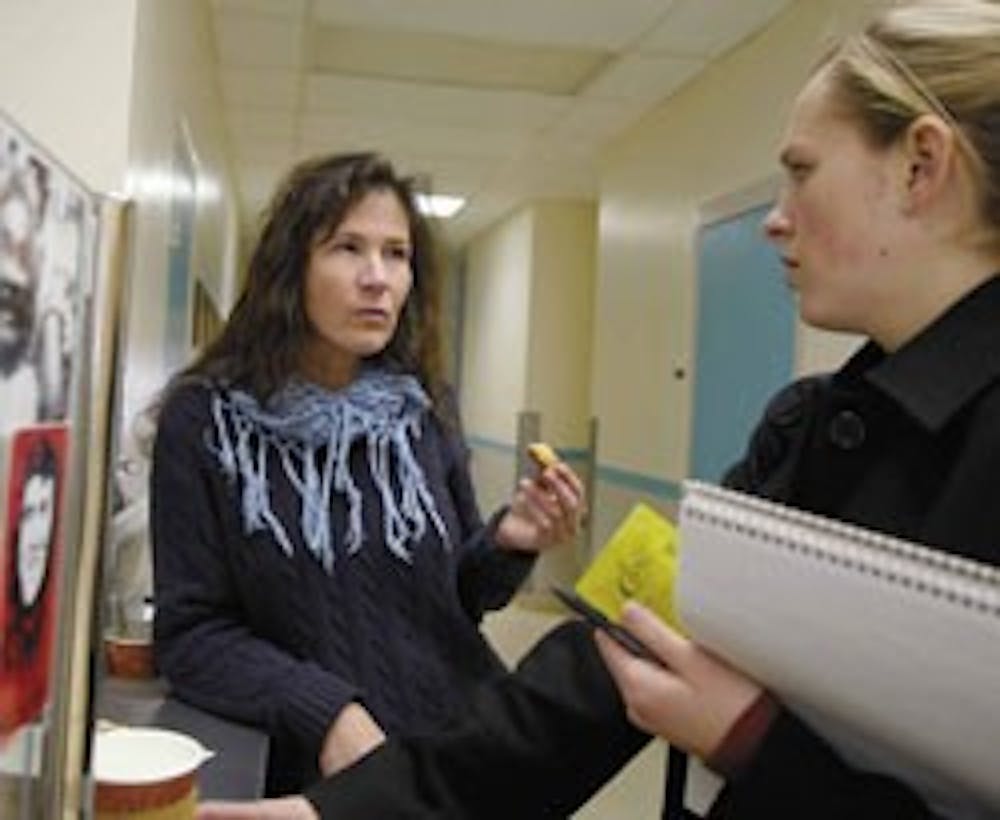 Assistant professor Marie Mugavin, left, talks to public affairs representative Lauren Cruse while getting coffee in the Health Sciences Center on Tuesday. Mugavin was the first nurse to earn a Ph.D. at UNM's nursing school.