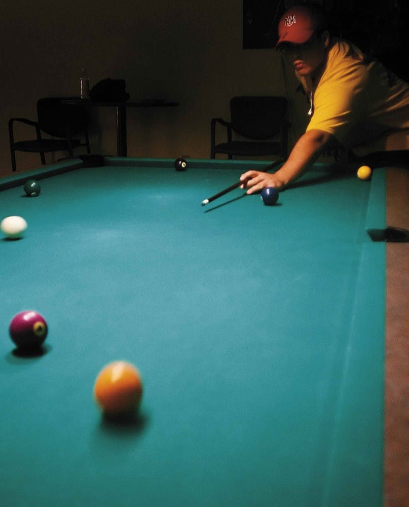 Student Matthew Garcia plays pool at the game room in the SUB on Thursday.  