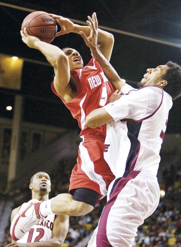 UNM's Dairese Gary shoots while NMSU's Martin Iti tries to block during Tuesday's game at The Pan American Center in Las Cruces. The Lobos lost 71-62. 