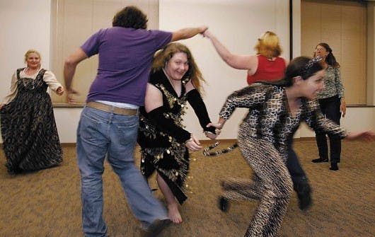 Society for Creative Anachronism at UNM members Lora Smalley, center left, and Rachael Falcon pass under fellow members as a part of the Posties Jig during the group's Monday dance practice in the SUB.
