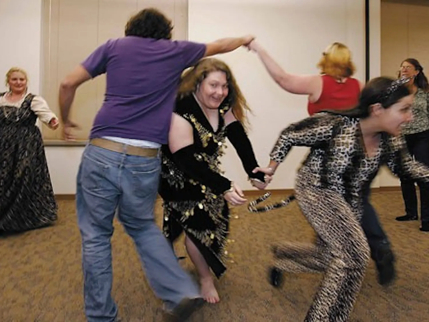 Society for Creative Anachronism at UNM members Lora Smalley, center left, and Rachael Falcon pass under fellow members as a part of the Posties Jig during the group's Monday dance practice in the SUB.