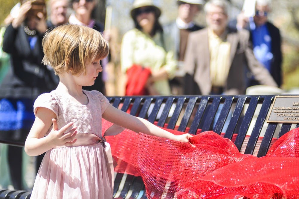 Lyra Zink, stands at the memorial dedicated to her grandfather, the late professor Lee B. Zink, on Saturday afternoon outside Terrace Mall. Zink was a co-founder and first president of the UNM Retiree Association and was also a professor of economics to over 7,000 students while at UNM.&nbsp;