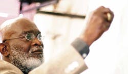 Former African American Studies director Shiame Okunor writes on a chalkboard in Mitchell Hall on Wednesday. Okunor will retire at the end of the semester after 25 years at UNM.