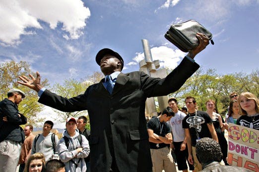 The Rev. Michael Venyah preaches to a crowd outside the SUB on Thursday. Venyah and his family have been touring college campuses in their RV since 2004.