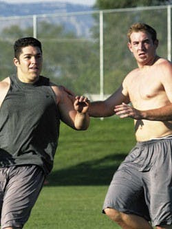 UNM quarterback Kole McKamey, right, scrimmages July 20 at the Lobo football practice field.