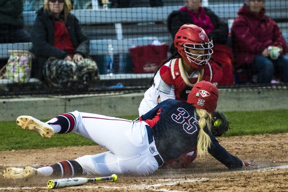 Lobos freshman catcher Jade Gray fails to apply the tag as Fresno State's Paige Gumz slides into home plate Friday night at the Lobo Softball Field. UNM has fallen to Fresno State in both games of their series thus far, by a combined score of 17-7.&nbsp;