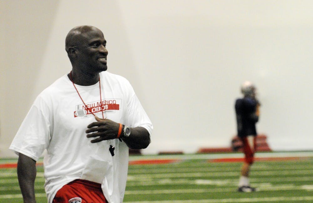 	George Barlow strolls down the sidelines on Tuesday at the Lobos’ Indoor Practice Facility. Barlow, UNM’s interim head coach, will wear the headset in place of Mike Locksley during Saturday’s home game against UNLV. Locksley is serving part of his 10-day suspension as a result of his altercation with assistant coach J.B. Gerald.