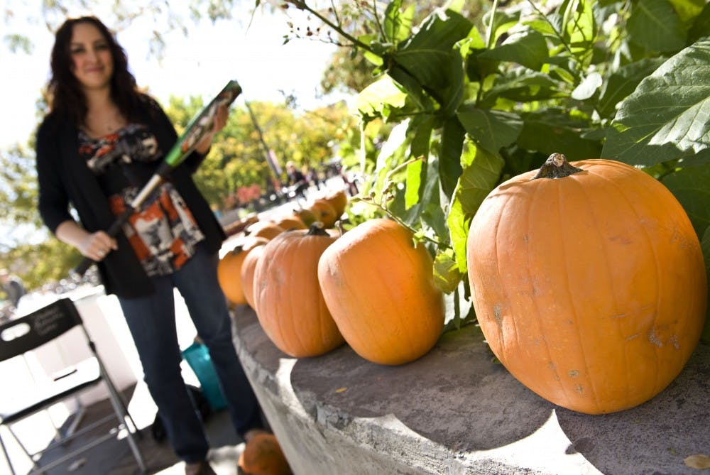 	Student Felicia Alexander stands with a baseball bat outside the SUB on Tuesday. Her group, Nourish International, held a bake sale and pumpkin-smashing event to raise money for sustainable organic agriculture in Nicaragua and Guatemala. 