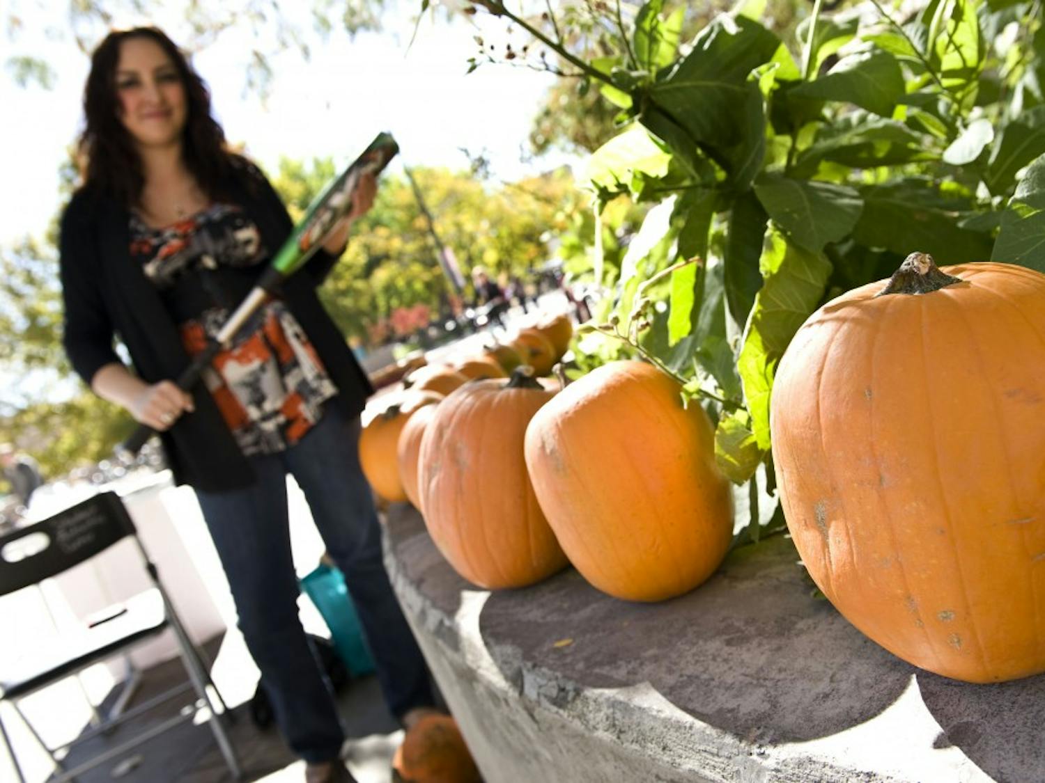 	Student Felicia Alexander stands with a baseball bat outside the SUB on Tuesday. Her group, Nourish International, held a bake sale and pumpkin-smashing event to raise money for sustainable organic agriculture in Nicaragua and Guatemala. 