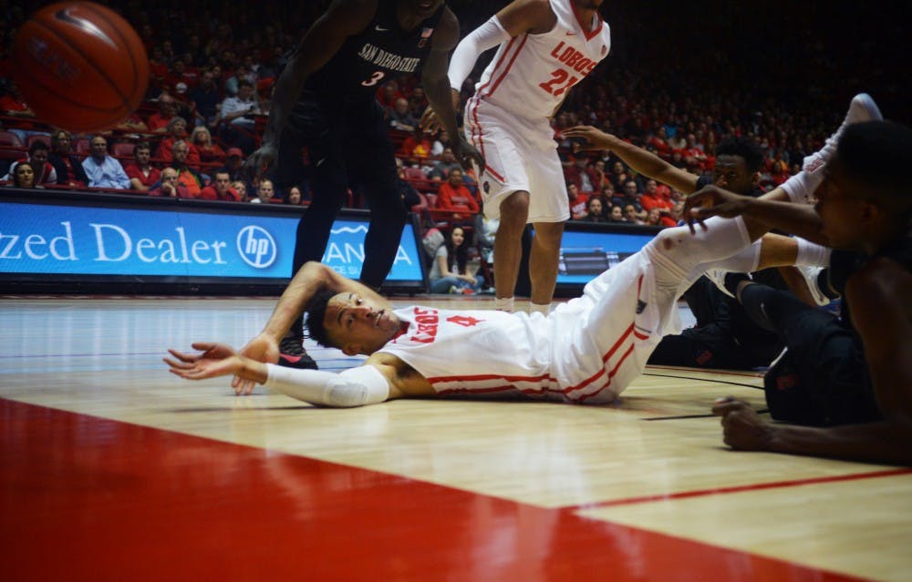 Redshirt sophomore guard Elijah Brown (4) reaches out as players scramble for the ball Tuesday night at WisePies Arena. The Lobos lost their last home game this season to San Diego State University 83-56.