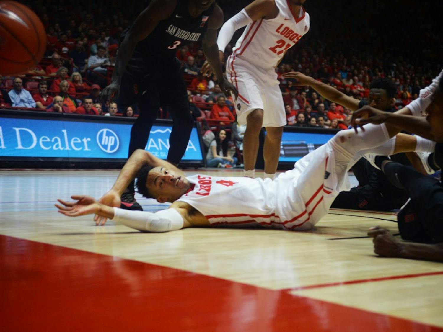 Redshirt sophomore guard Elijah Brown (4) reaches out as players scramble for the ball Tuesday night at WisePies Arena. The Lobos lost their last home game this season to San Diego State University 83-56.