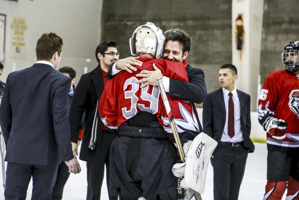 UNM head hockey coach Grant Harvey embraces goalie James Bostian after the overtime win against Colorado Mesa University, 5-4.