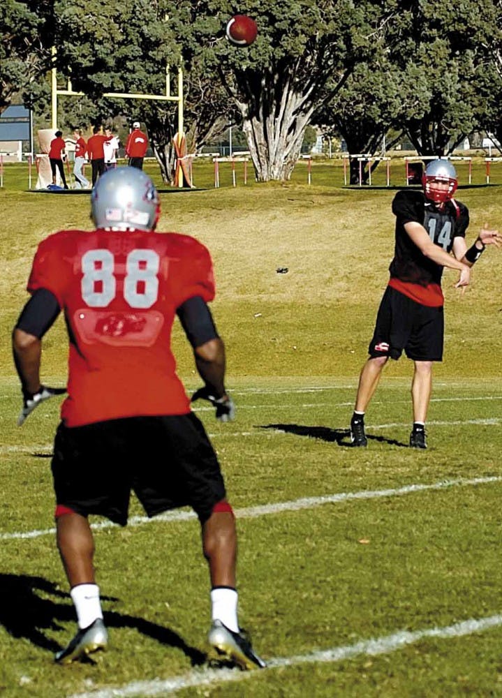 Lobo backup quarterback Bryan Clampitt throws a pass to wide receiver Daryl Jones during drills at the UNM football practice field.