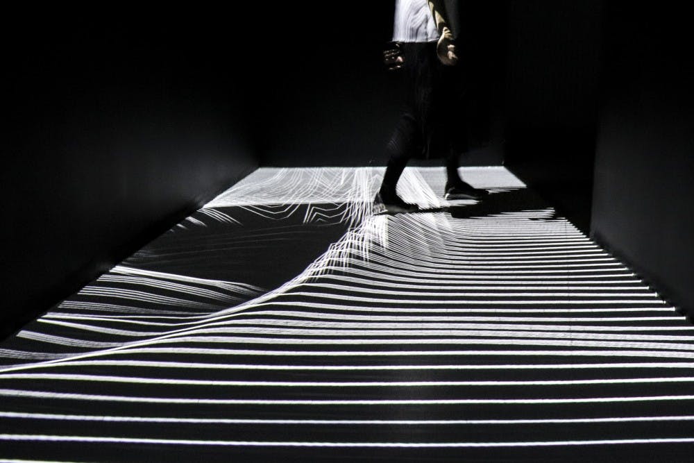 A guide walks through one of the interactive exhibits at the XYZ installation captured on June 27, 2018 at ARTECHOUSE in Albuquerque.