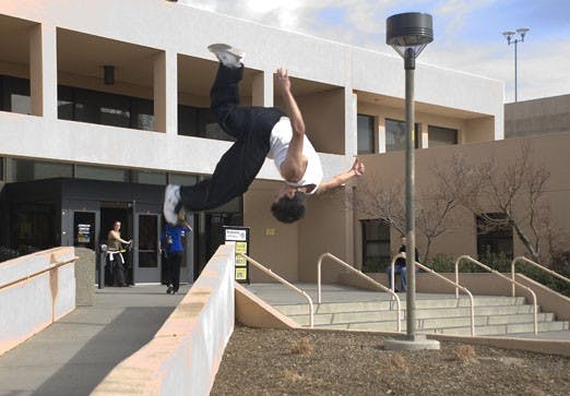 Zack Wright somersaults from a walkway outside Johnson Gym on Wednesday.